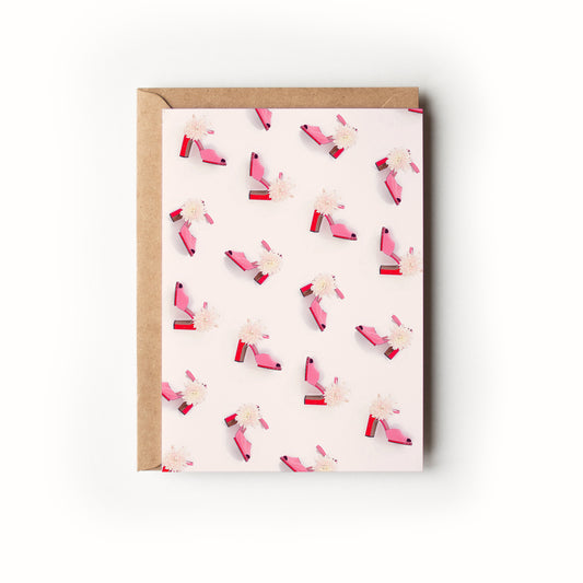 Greeting card with pink and red shoes on an off-white background
