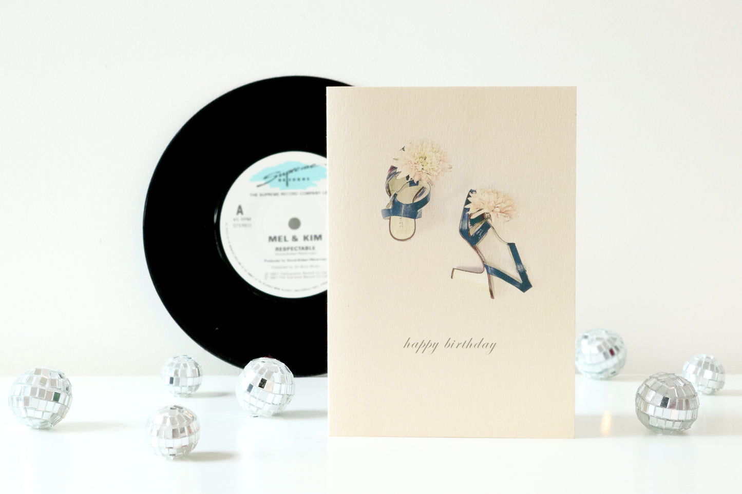 Vinyl record and birthday card with shoes on a white background