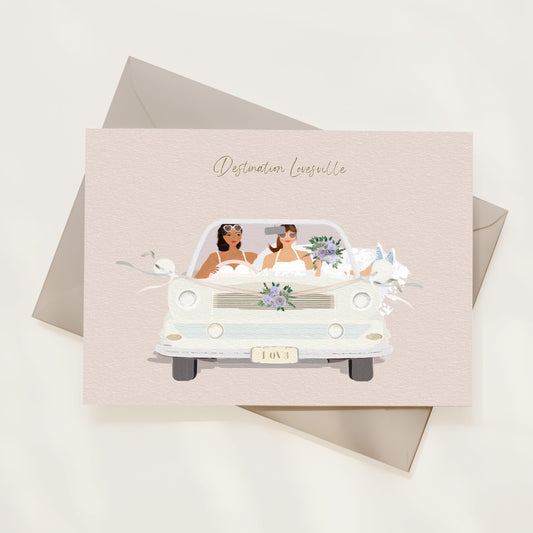 Greeting card with illustration of a car carrying two brides, set against a light background.