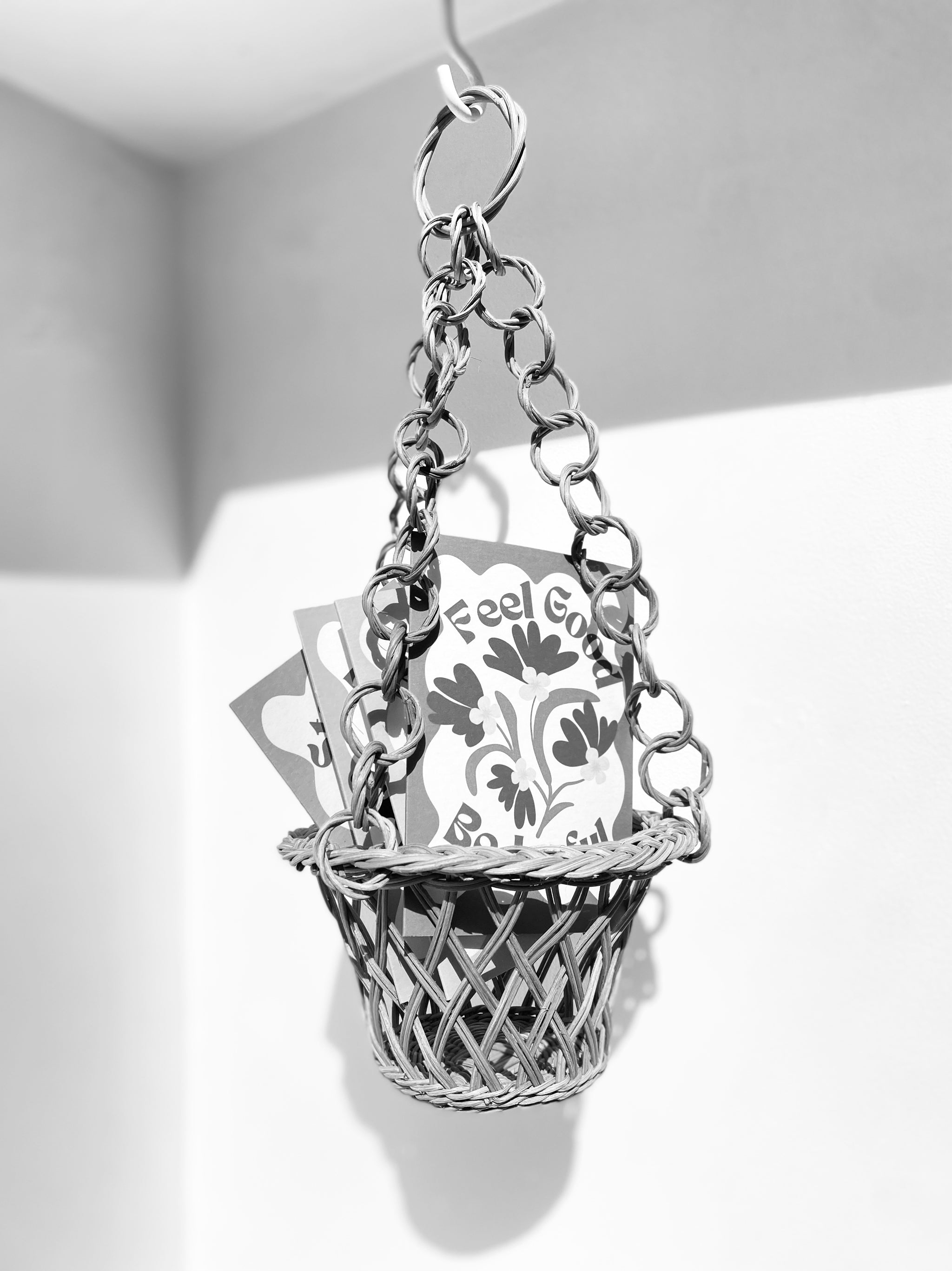 Retro Floral design cards in a hanging wicker basket on a white background