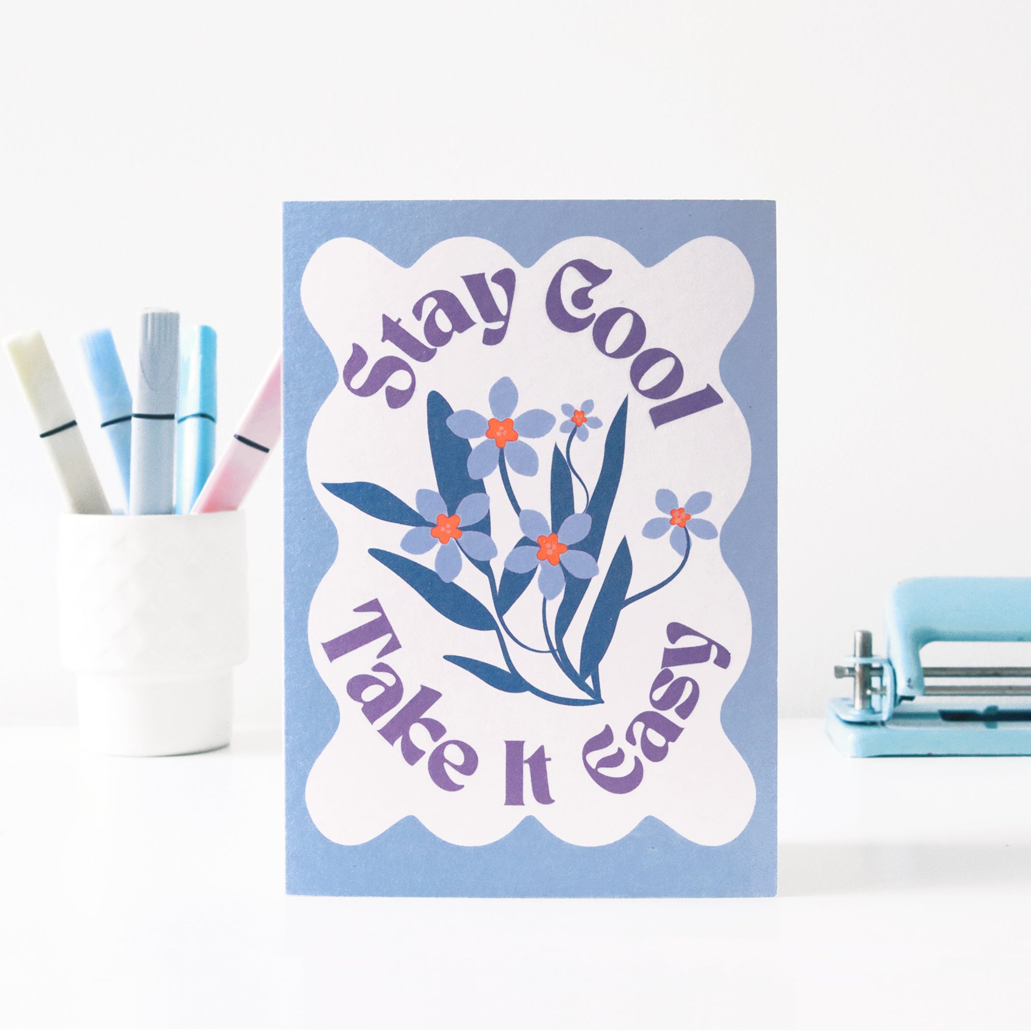 Card with floral design and text 'stay cool, take it easy' on a light blue background.