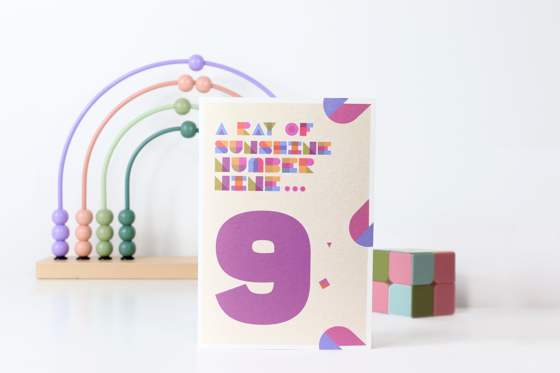 Card with number 9 and colorful abacus on a white background