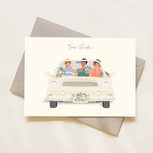 Card with illustration of a vintage car carrying three women labelled 'Team Bride' on a white background.